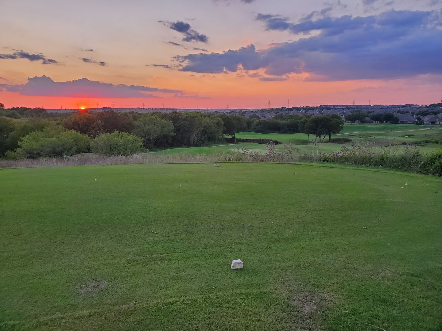 Course fairway view with trees and rolling terrain