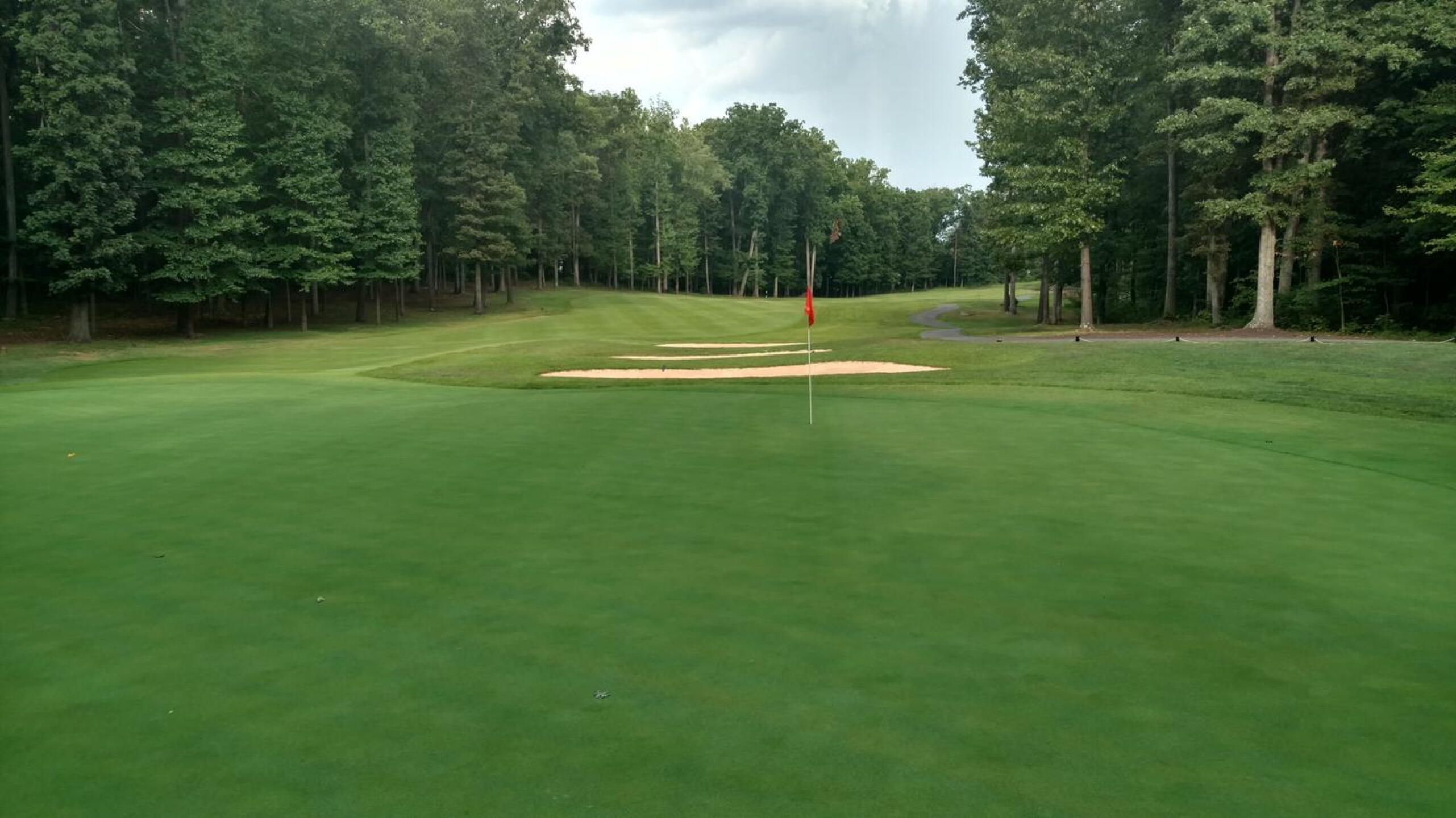 The par-4 11th, one of the few that has a tree-lined fairway, but makes up for it with a relatively flat green. (Photo submitted by Back9Ben on 08/01/2017)