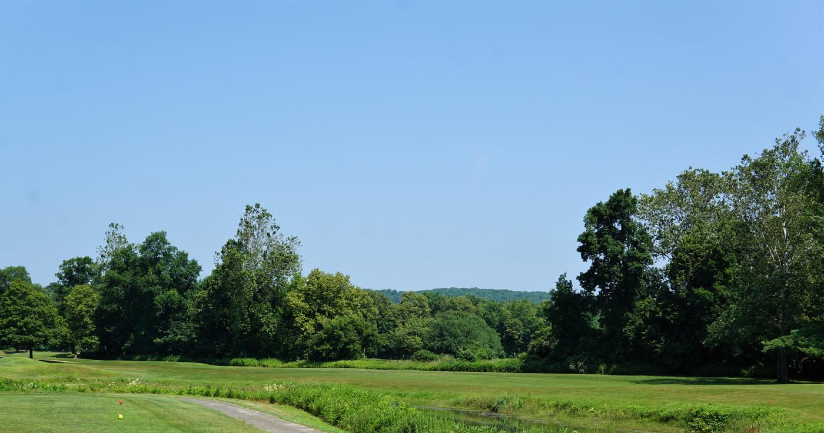 Seven, the number one handicap hole at Pomperaug, curves around a pond (looking back toward the tee). (Photo submitted by AptlyLinked on 07/08/2023)