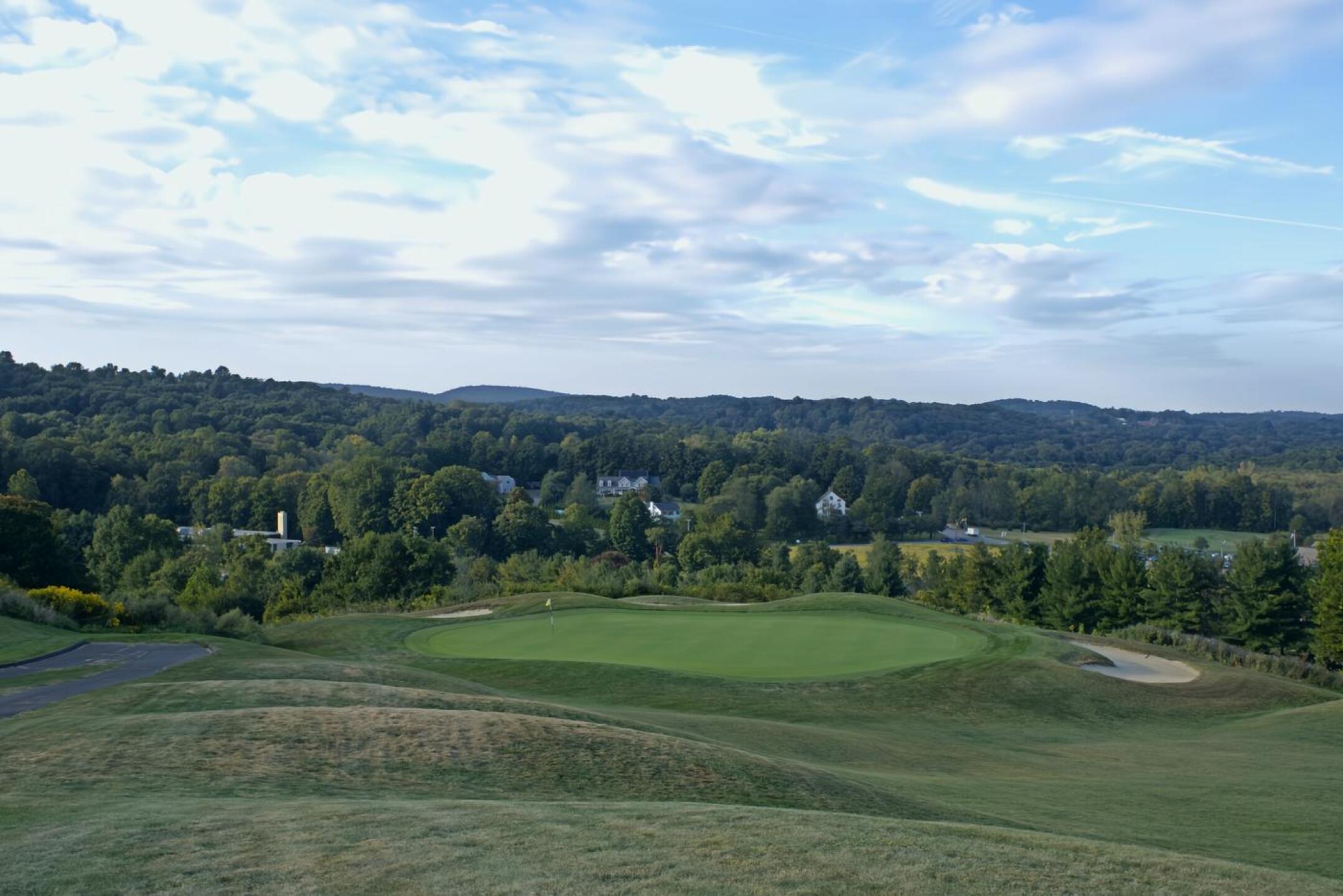 The par-3 eleventh stretches 211 yards downhill to a green protected by bunkers. Stretching out beyond that is a hilly Connecticut landscape. (Photo submitted by AptlyLinked on 09/22/2024)