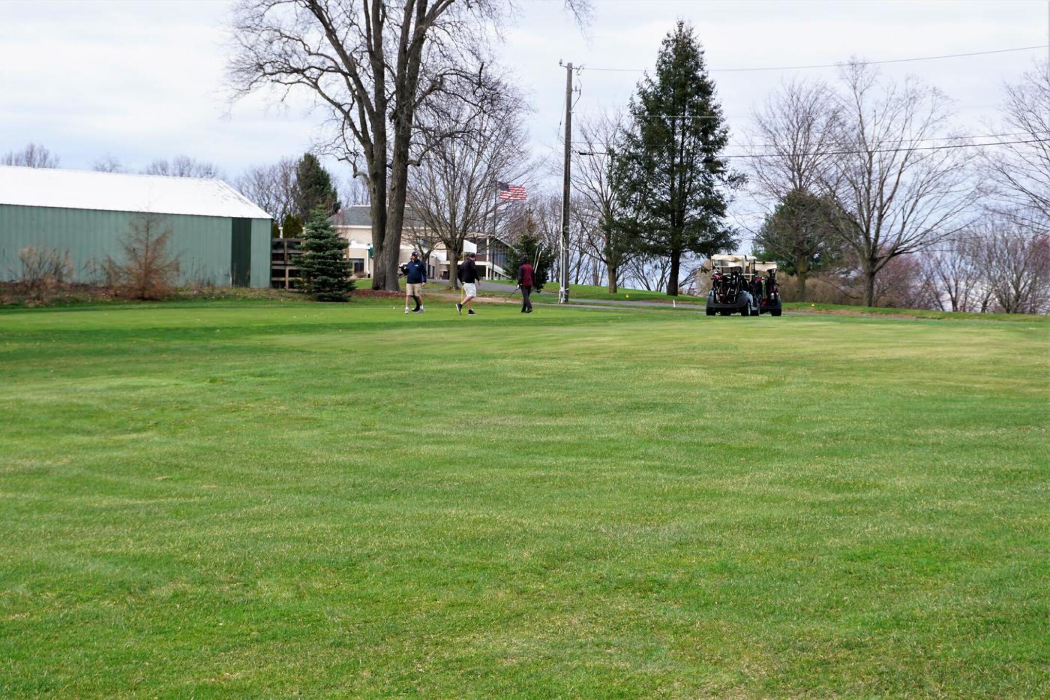 A foursome finishing up their round on green eighteen. (Photo submitted by AptlyLinked on 04/12/2022)