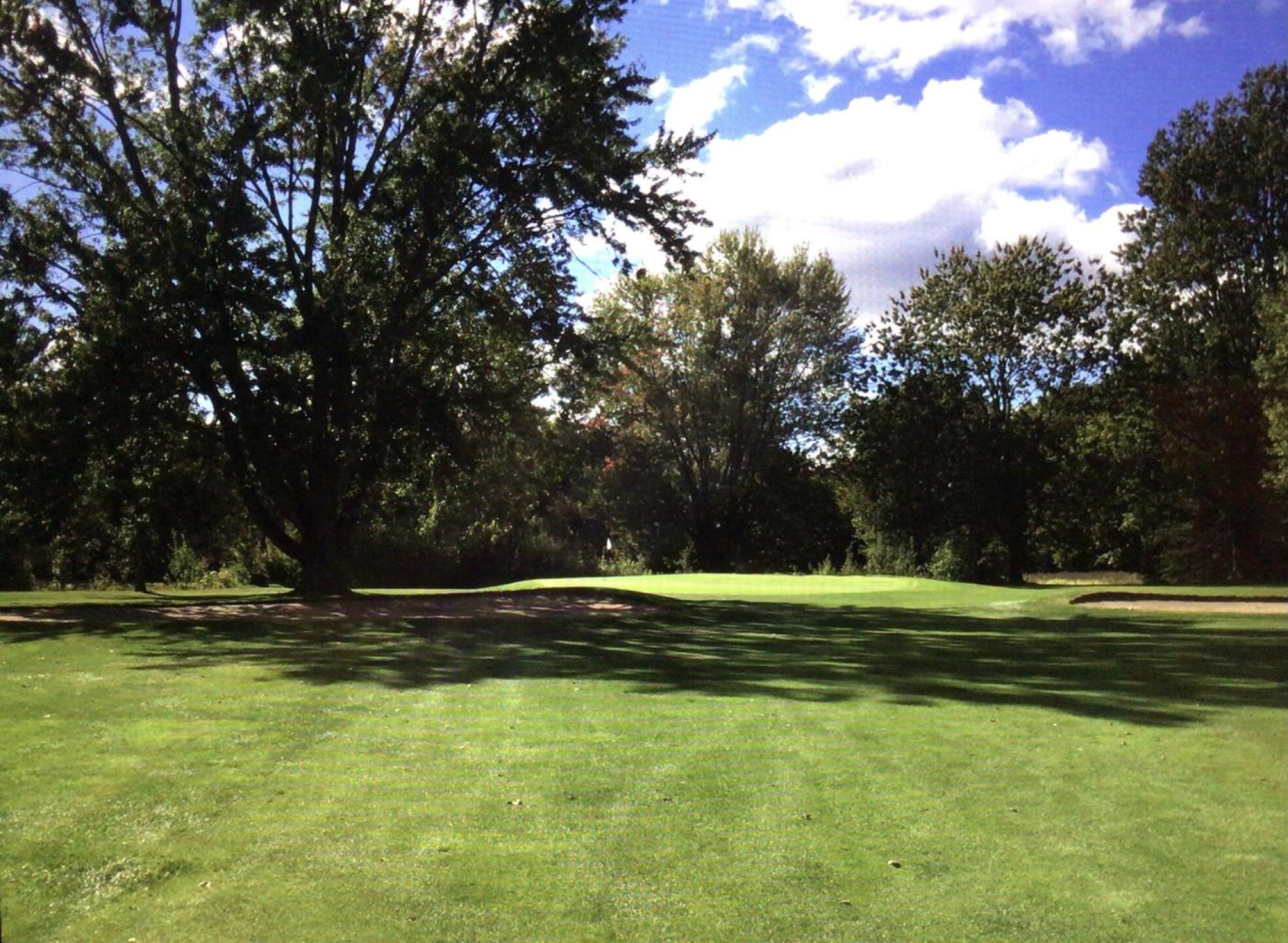 6th hole, par 4 of about 375.  Pond 220 yards off the tee so you have a decision to make.  If you bail out left, however, the tree on the left comes into play on your second shot, as it is between the bunker and the green. (Photo submitted by BuffaloBen15 on 10/26/2020)