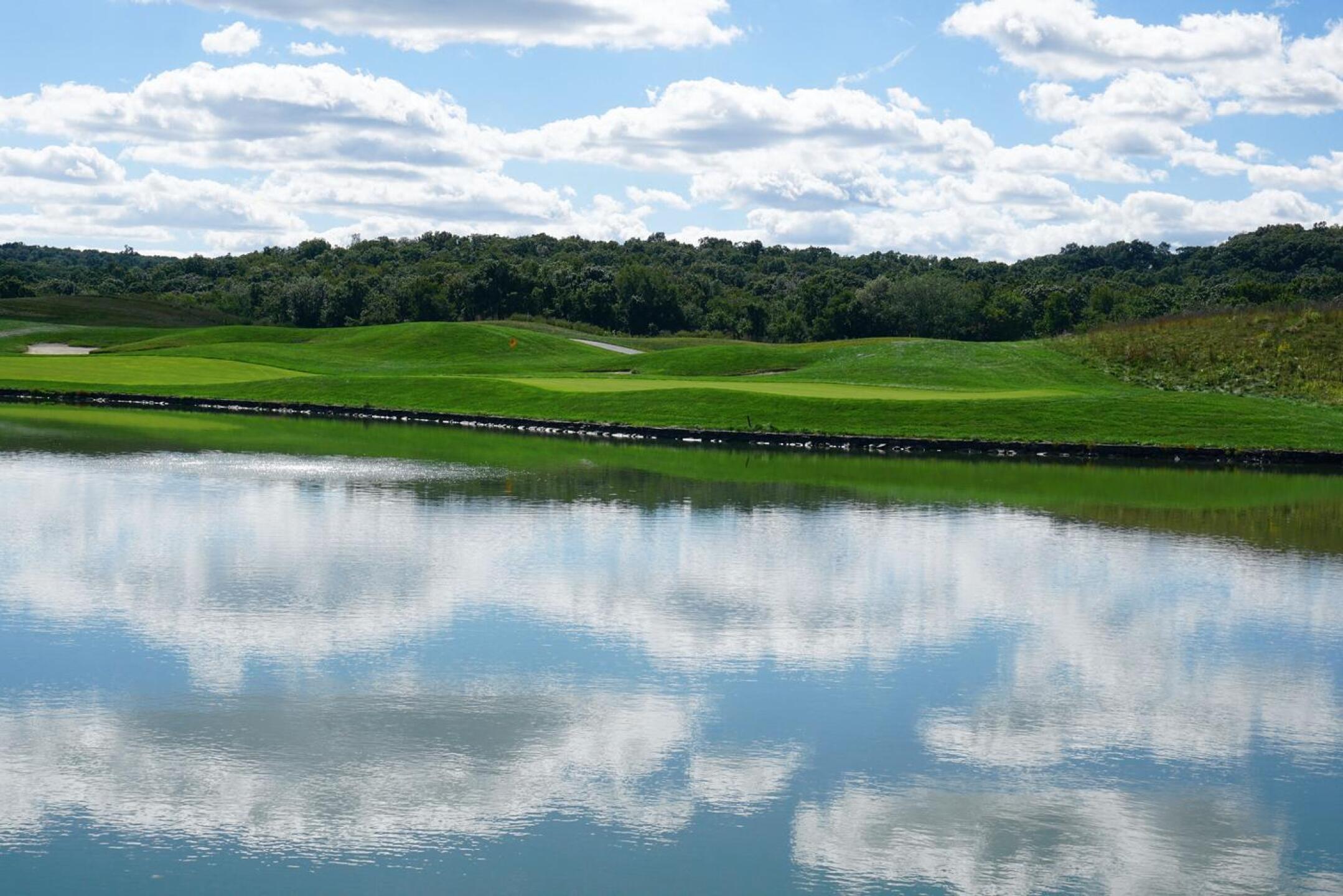 Eighteen, as seen from across the pond, near the entry drive. A ribbon of fairway; a green set hard by the water. (Photo submitted by AptlyLinked on 09/21/2021)