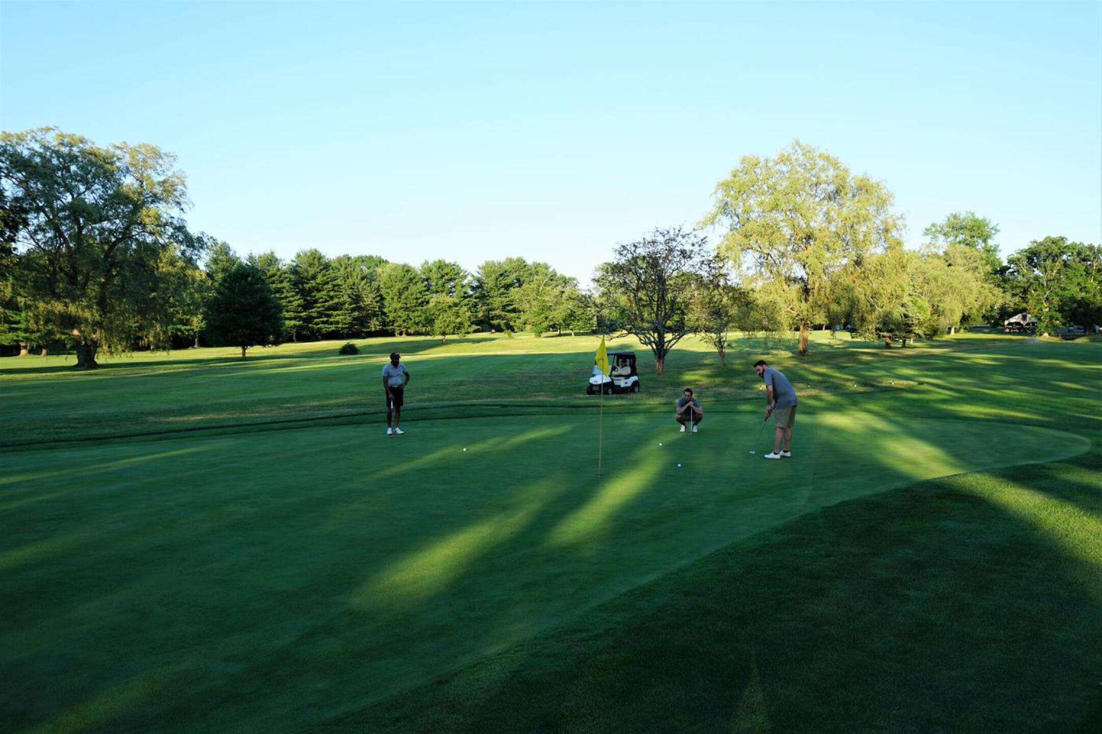 At green 1 are Harsh Patel (left), Matt Fresk (center) and Matt Dominioni, who made the putt (here rolling to hole). (Photo submitted by AptlyLinked on 07/09/2020)