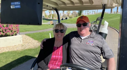 Non-golfing spouse riding a golf cart