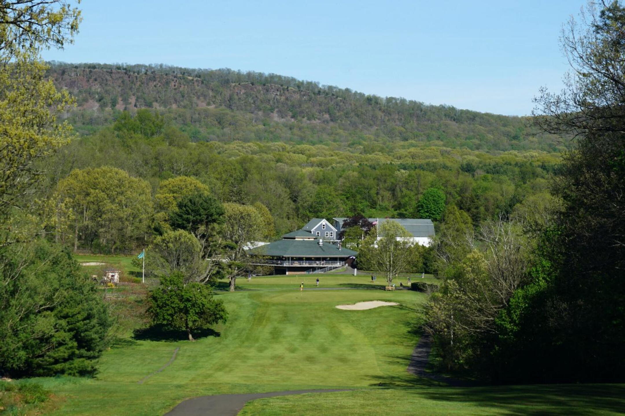 The ninth plummets to a narrow fairway. Behind the green: the practice putting green and Violi’s Restaurant. (Photo submitted by AptlyLinked on 05/13/2022)